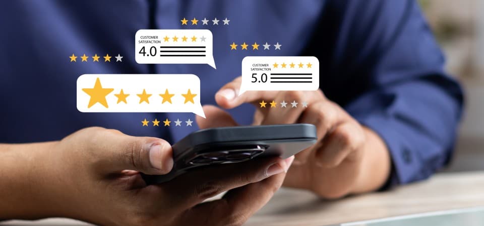 A person using a smartphone with star graphics representing online reviews popping out of the screen.