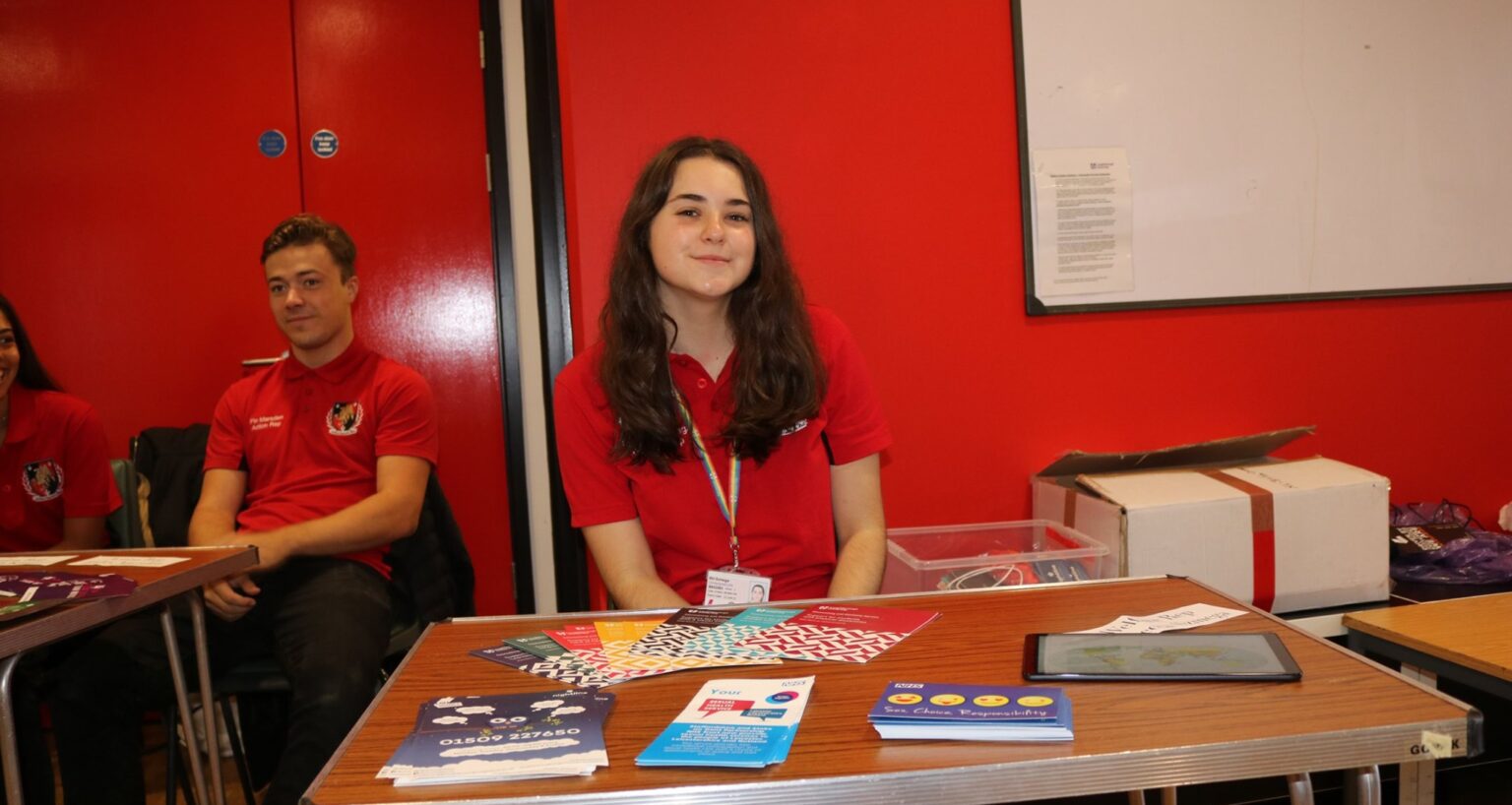 A female student sitting at a desk at a freshers fare