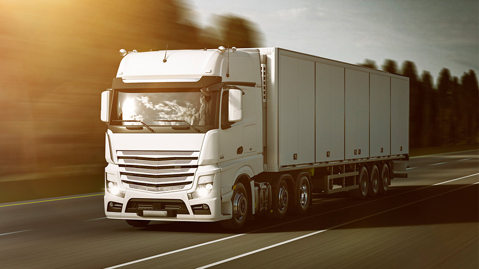 Pictured is a white lorry driving along a road. 