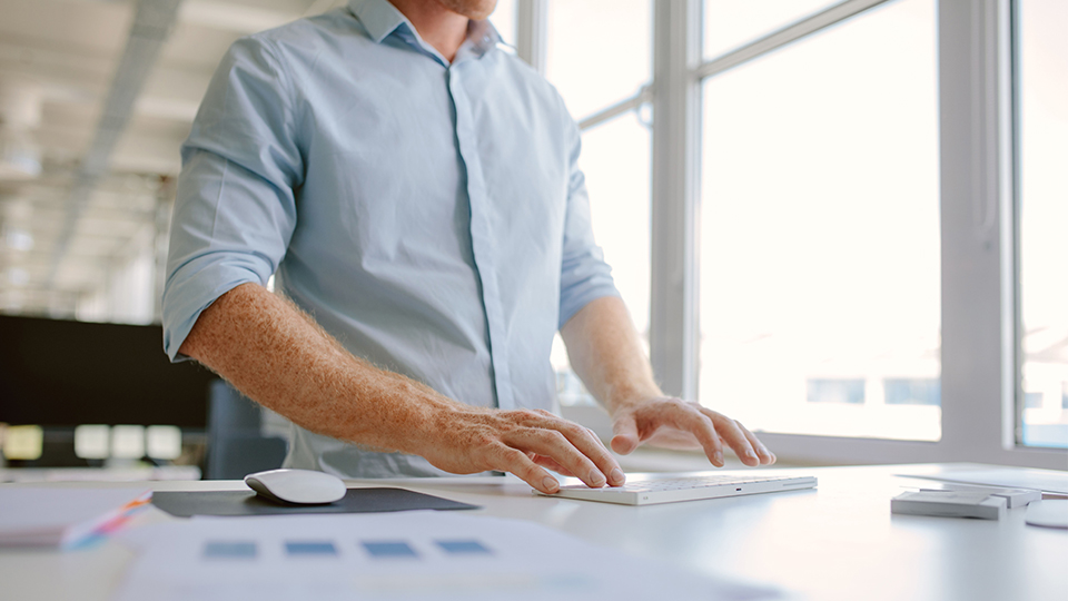 Photo of a man at a standing desk