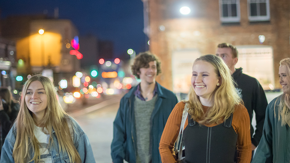 photo of a group of students walking around during the evening