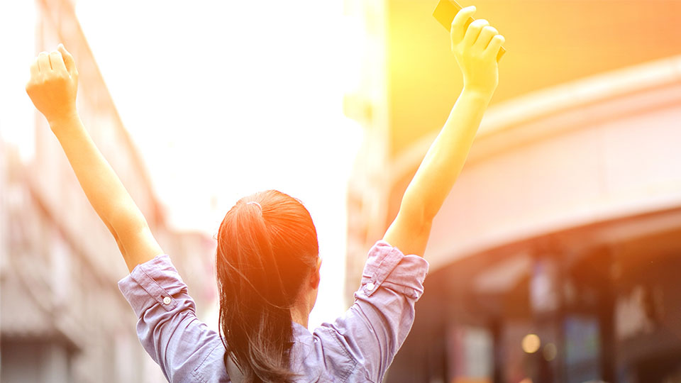 Young woman holding hands up to sky