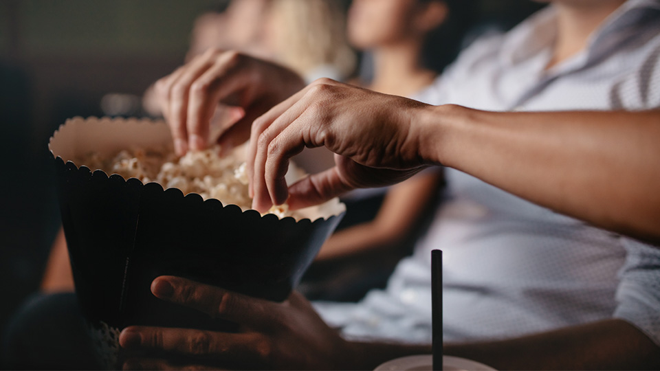 Pictured are people at the cinema eating popcorn. 