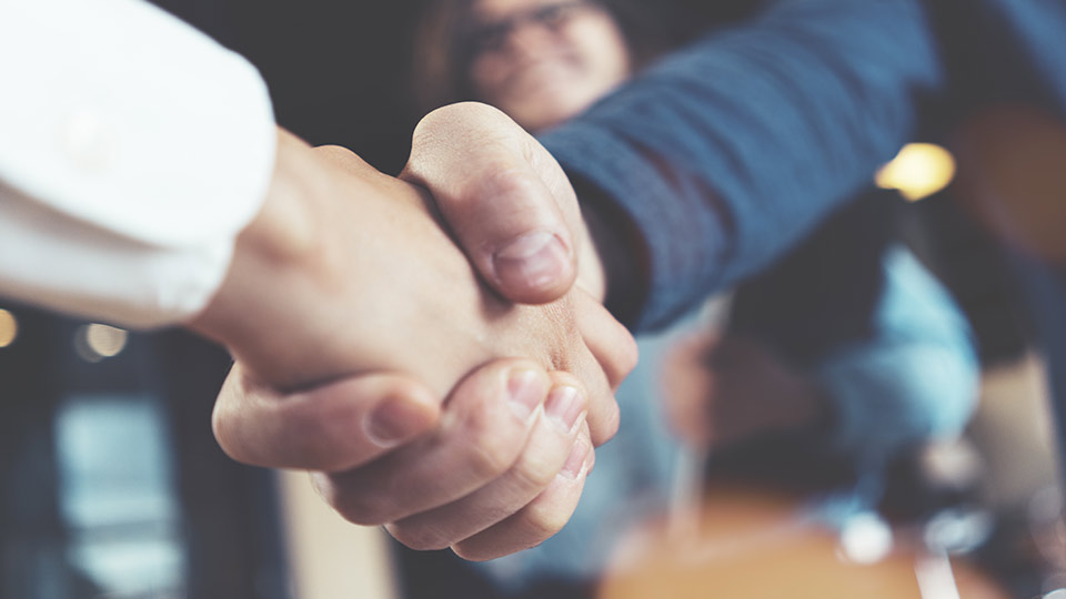 Pictured are people shaking hands. 