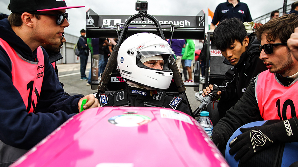 Photo of Monty in the driver's seat speaking to teammates 