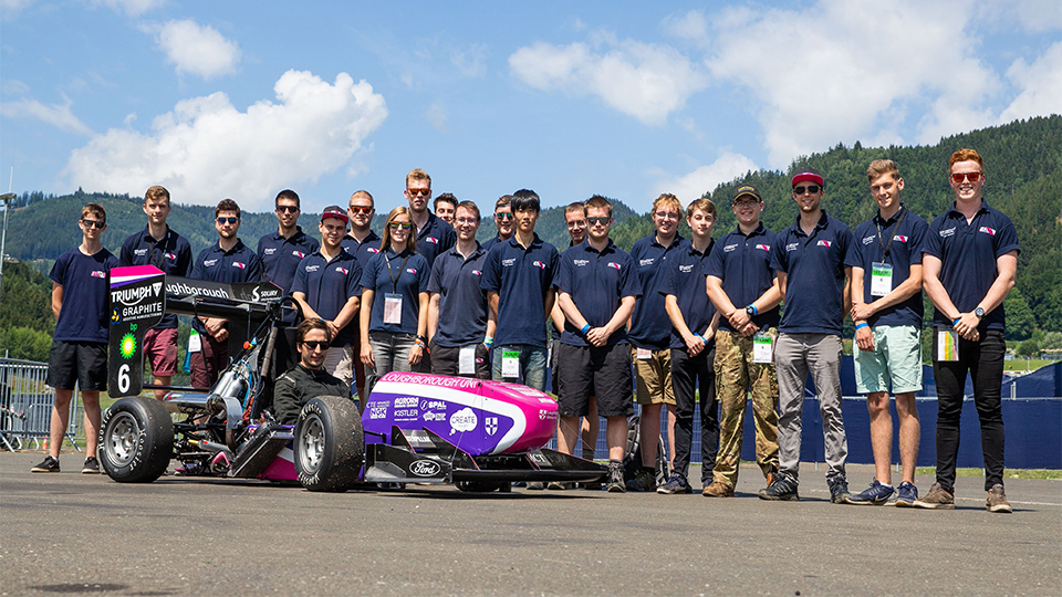 Photo of all of the 2019 team stood by the racecar