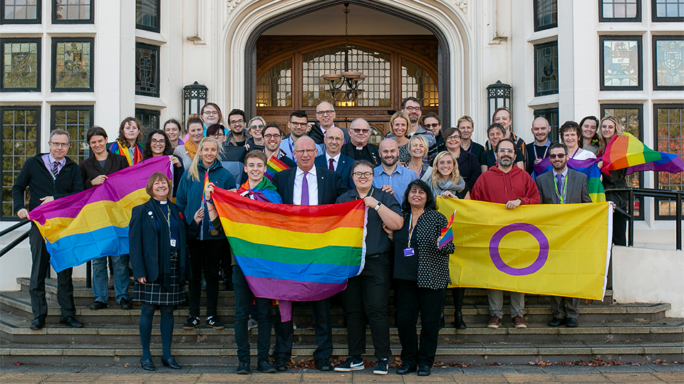 Photo of staff and students at celebration event on the steps outside Hazlerigg Building