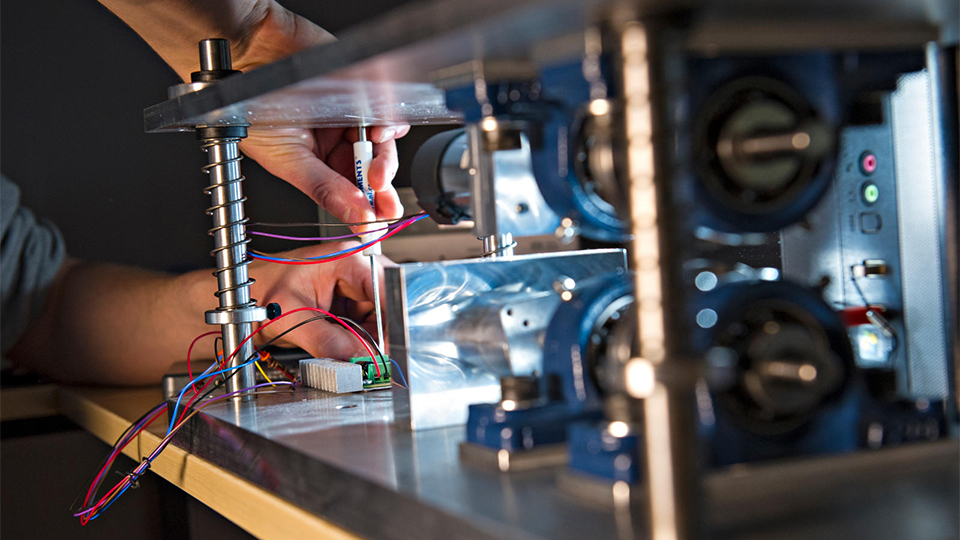 Photo of Electrical and Electronic engineering student working on a machine