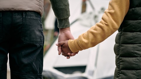 a child and parent holding hands