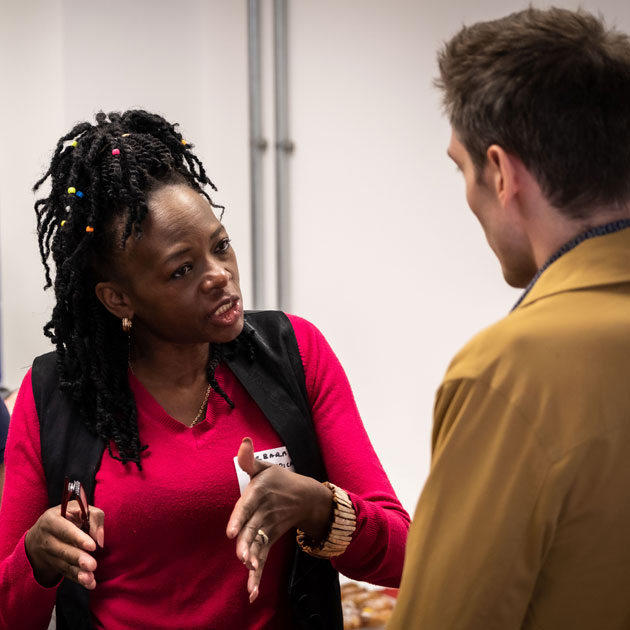 Workshop participant Barbara Attridge talking to an LUinc. member who has their back to us 