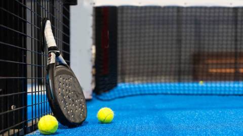 A padel racket leaning against a wall