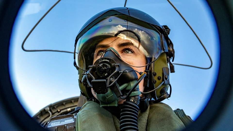 a close up of a female fighter pilot in the cockpit