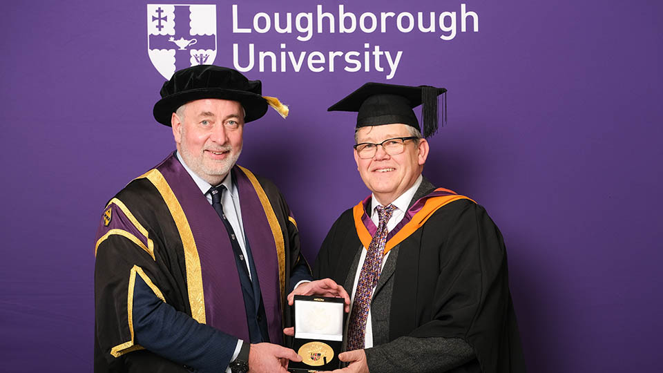 Andrew stood with the Vice-Chancellor holding his University Medal