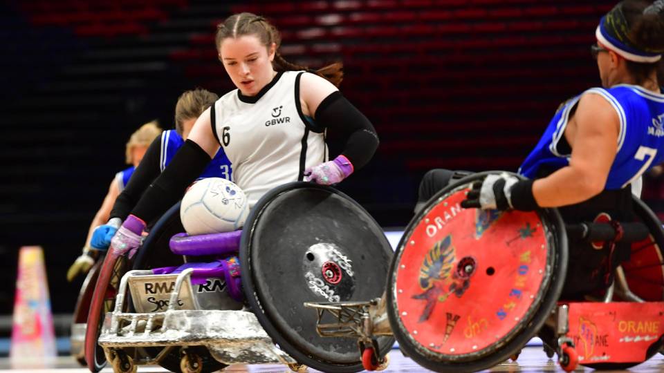 two female athletes compete for the ball in wheelchair rugby