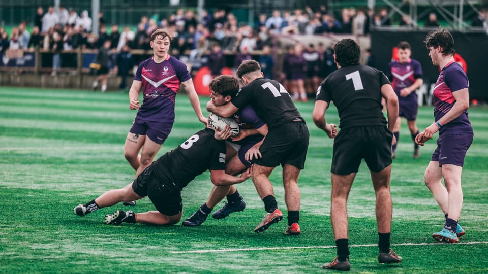 a rugby league player is tackled by an opponent