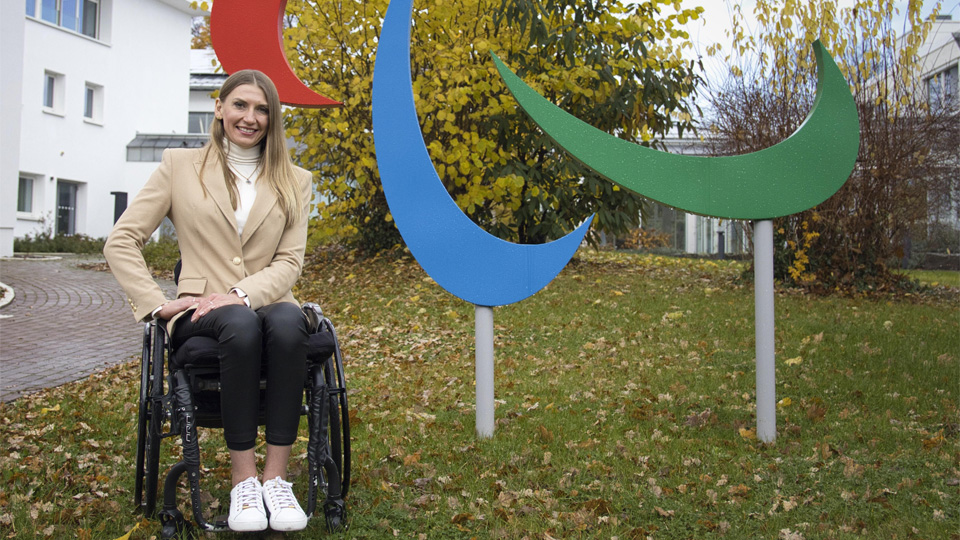 Vlady Kravchenko pose in front of the IPC sign in Bonn, Germany