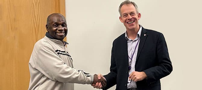 Sam Kayaga shaking hands with Malcolm Cook