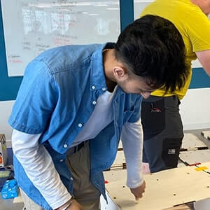 Nishil working in a studio on a small wooden architectural project