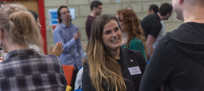 Training and events banner - doctoral researchers at a conference chatting during the break