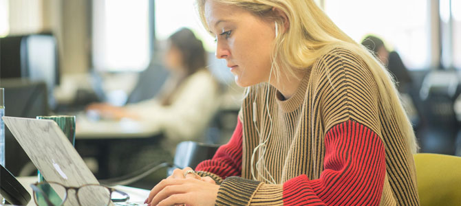 Student working on a laptop in a shared learning environment