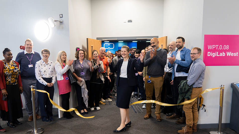 Prof Rachel Thomson cutting a ribbon in the DigiLab West in front of guests