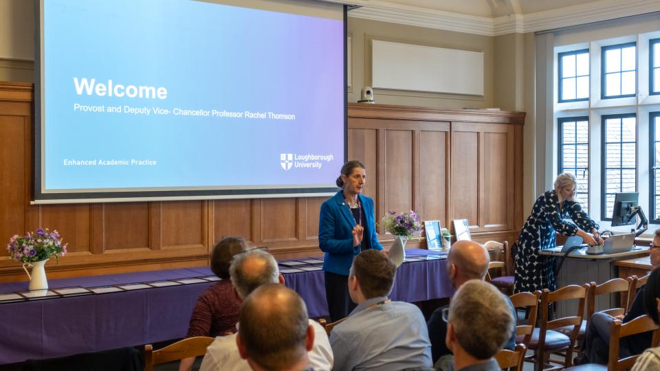 Professor Rachel Thomson stood in front of a group of staff with a large screen behind her